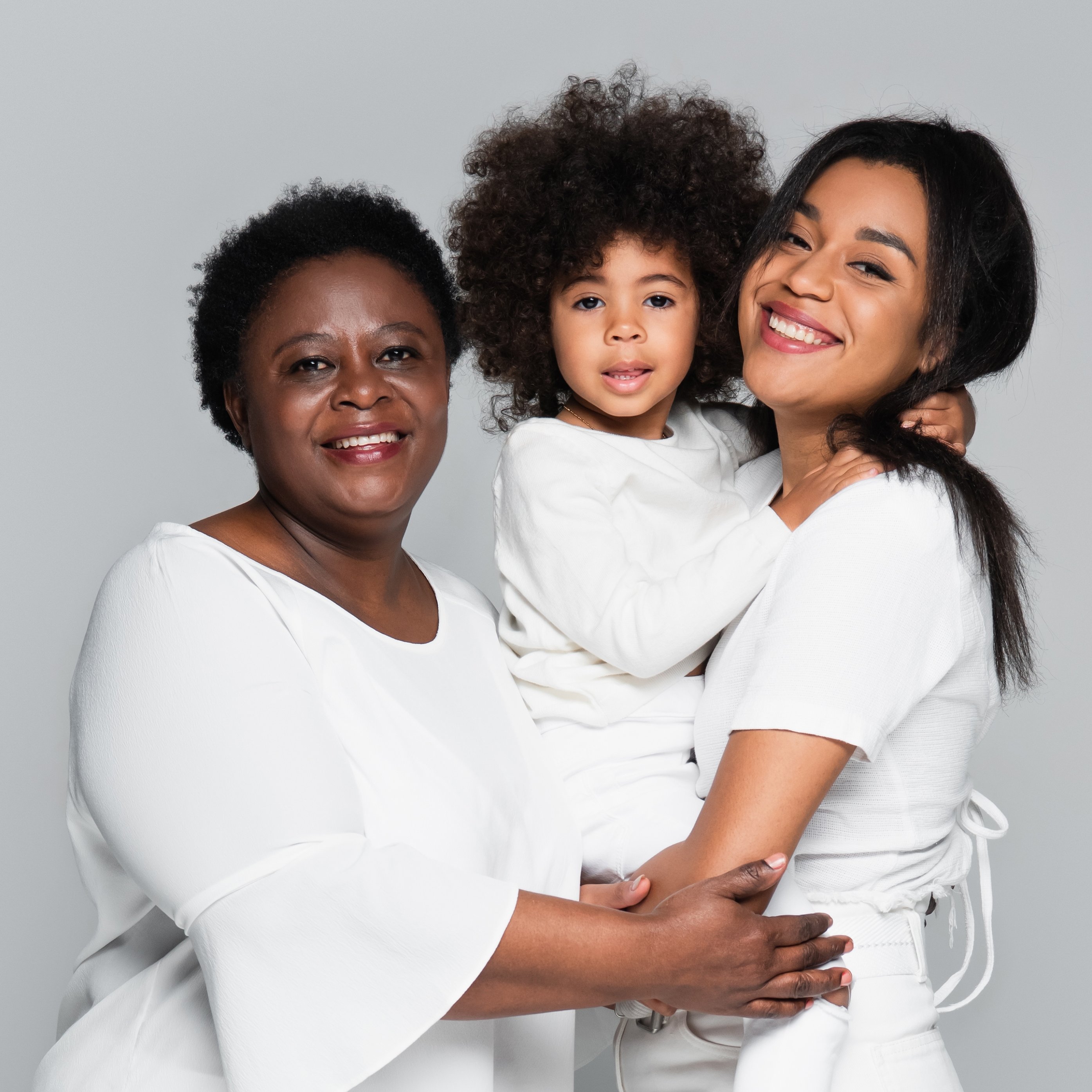 Junge afrikanische-amerikanische Frau mit Mutter und Tochter, lächelnd und sich gegenseitig umarmend ©LightField Studios/Shutterstock.com 